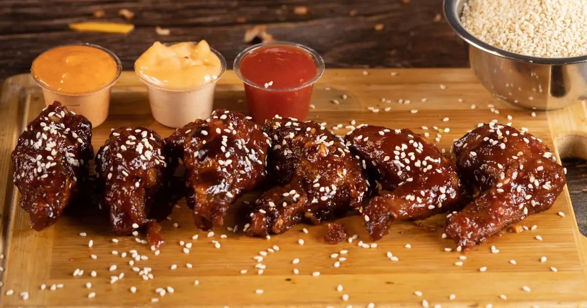 Buffalo-style chicken wings with sesame seeds and dipping sauces - The best Wingstop flavors: our picks for every taste