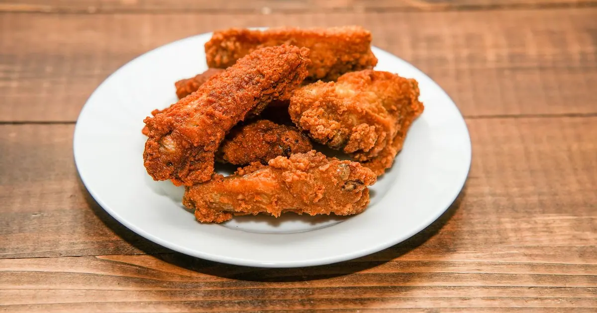 Crispy chicken wings on a white plate - Sweet Wingstop flavors, and how much sugar they carry