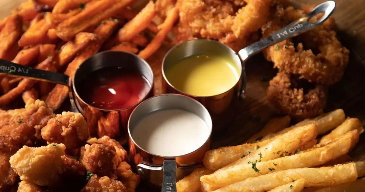 Wings and fries on a table - Wingstop flavors by heat level, from no heat to extra hot