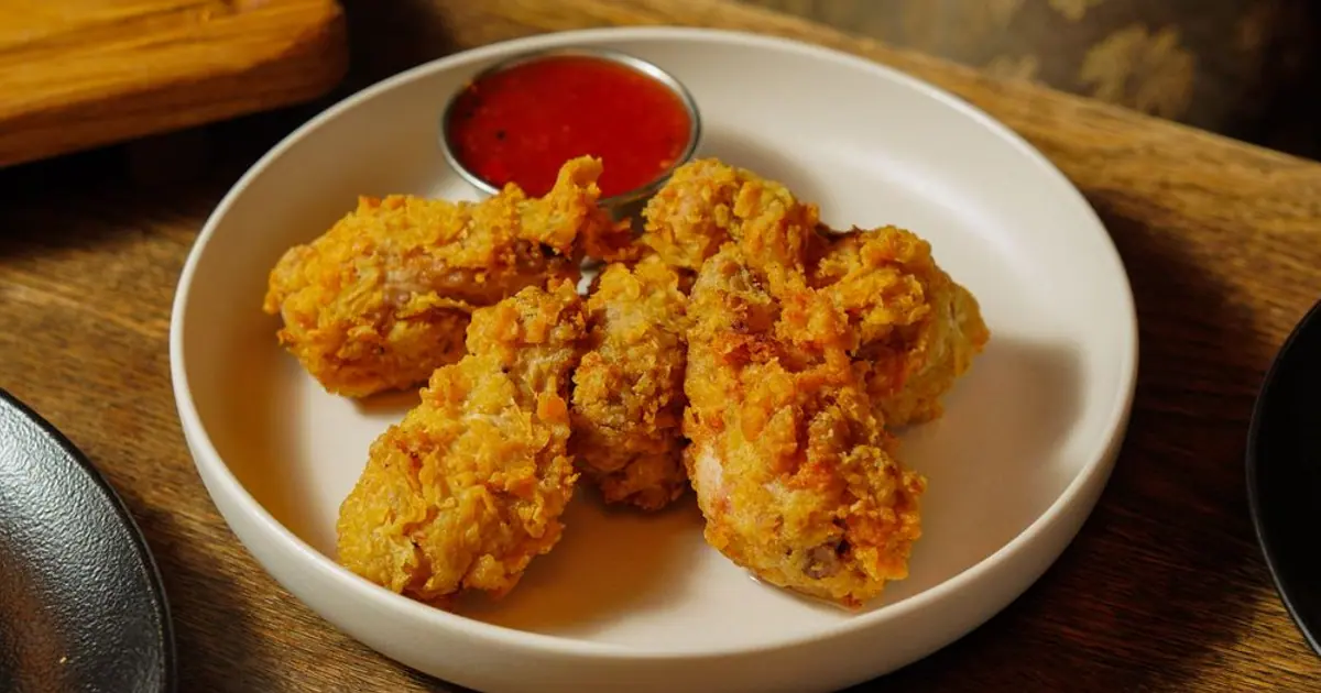 A small plate of crispy chicken wings with sauce - Wingstop flavors ranked by calories
