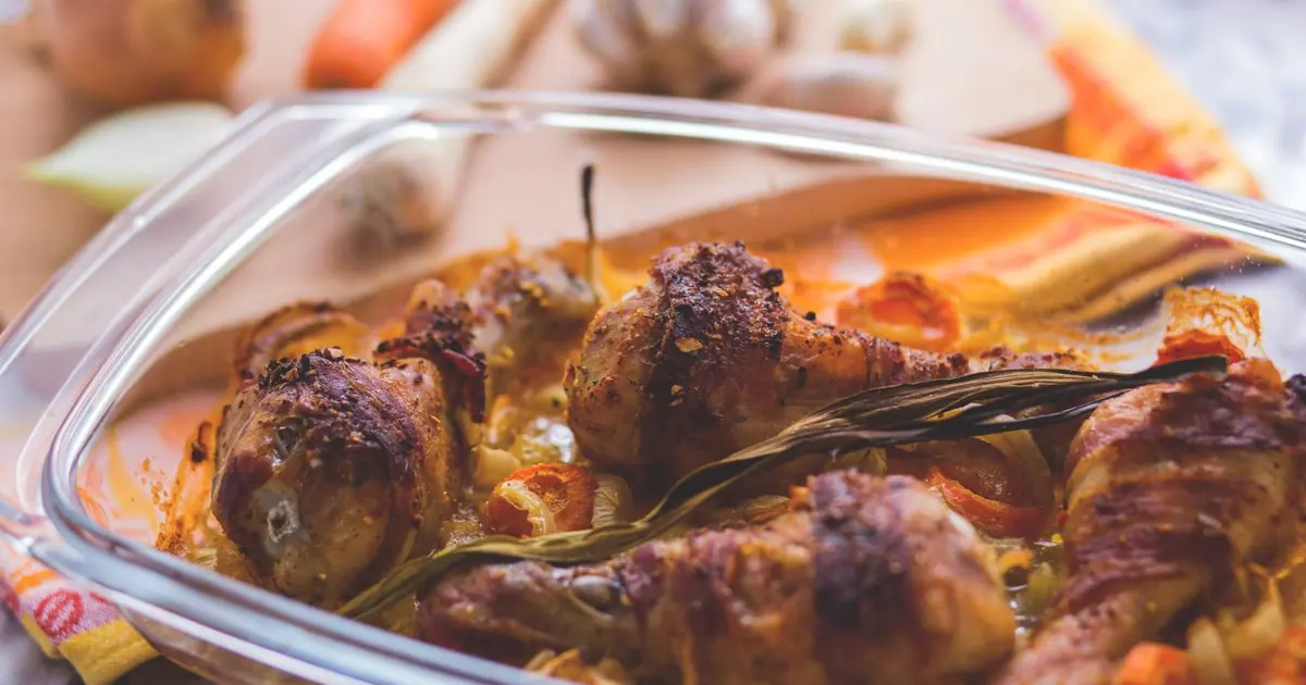 Roasted chicken pieces in a clear takeout tray - Is Wingstop gluten free? What the allergen guide says